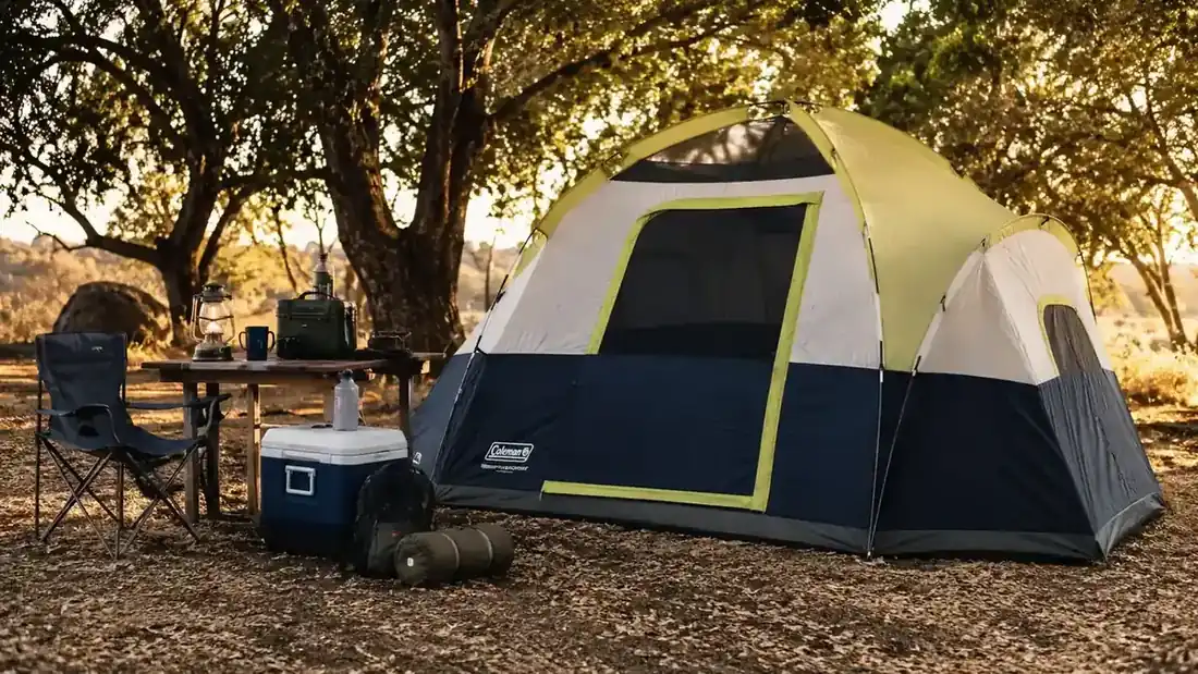 Green dome tent set up at a wooded northeast Oklahoma campsite in late afternoon light with camp chairs out front