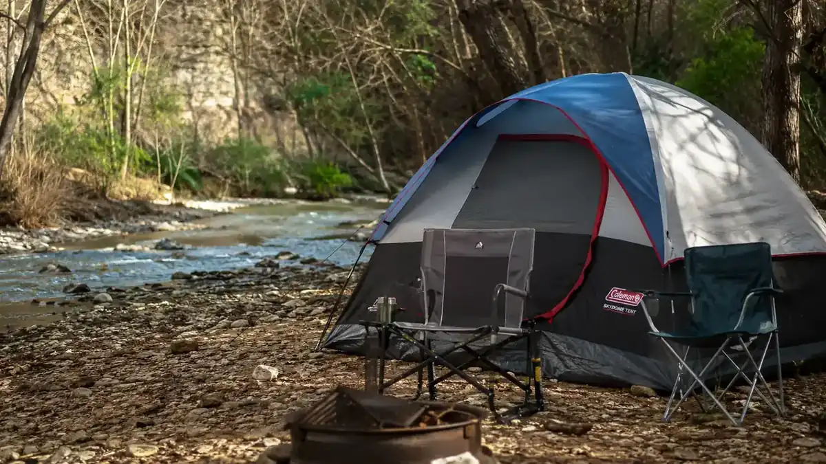 Coleman Skydome tent pitched on a rocky riverside campsite near Turner Falls with camp chairs out front