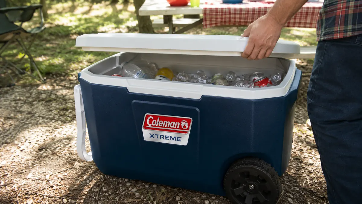 Hand lifting the lid of the Coleman Xtreme rolling cooler to check ice on the fourth day of a trip