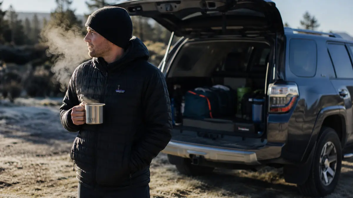 A family packing up a frosted campsite the next morning near a 2016 Toyota 4Runner